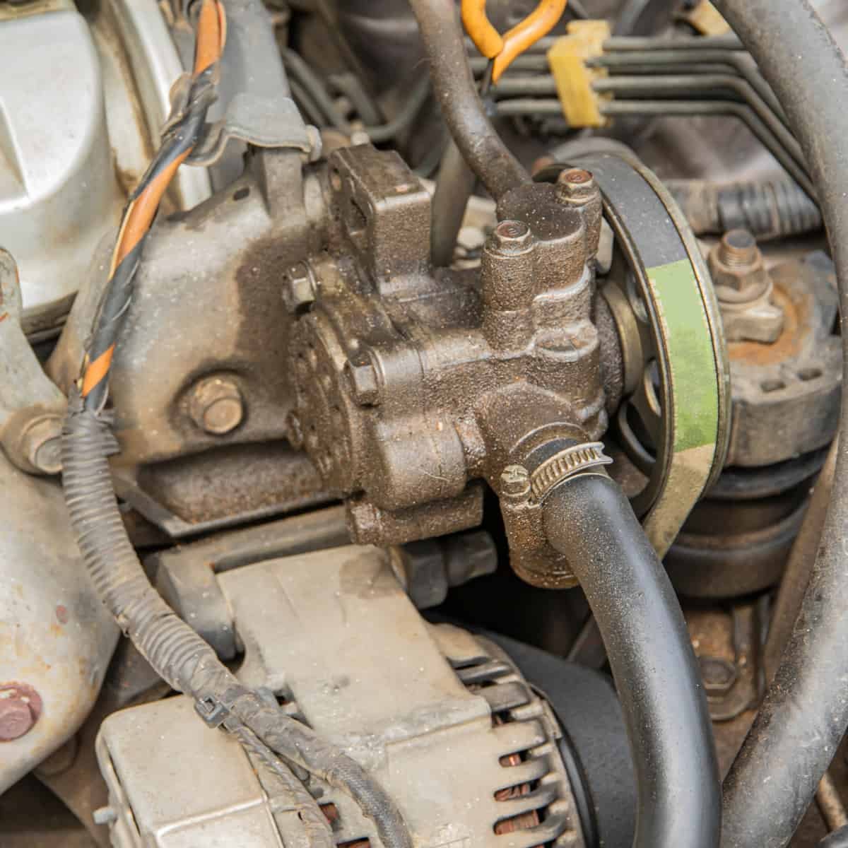Revisión de la bomba de dirección hidráulica y el depósito de líquido de un carro usado durante el peritaje